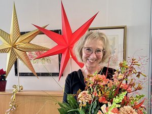 Zeit für Neues – Bärbel Maas verabschiedet sich in den Ruhestand. Sie hält einen großen Blumenstrauß in den Händen und lächelt fröhlich. 