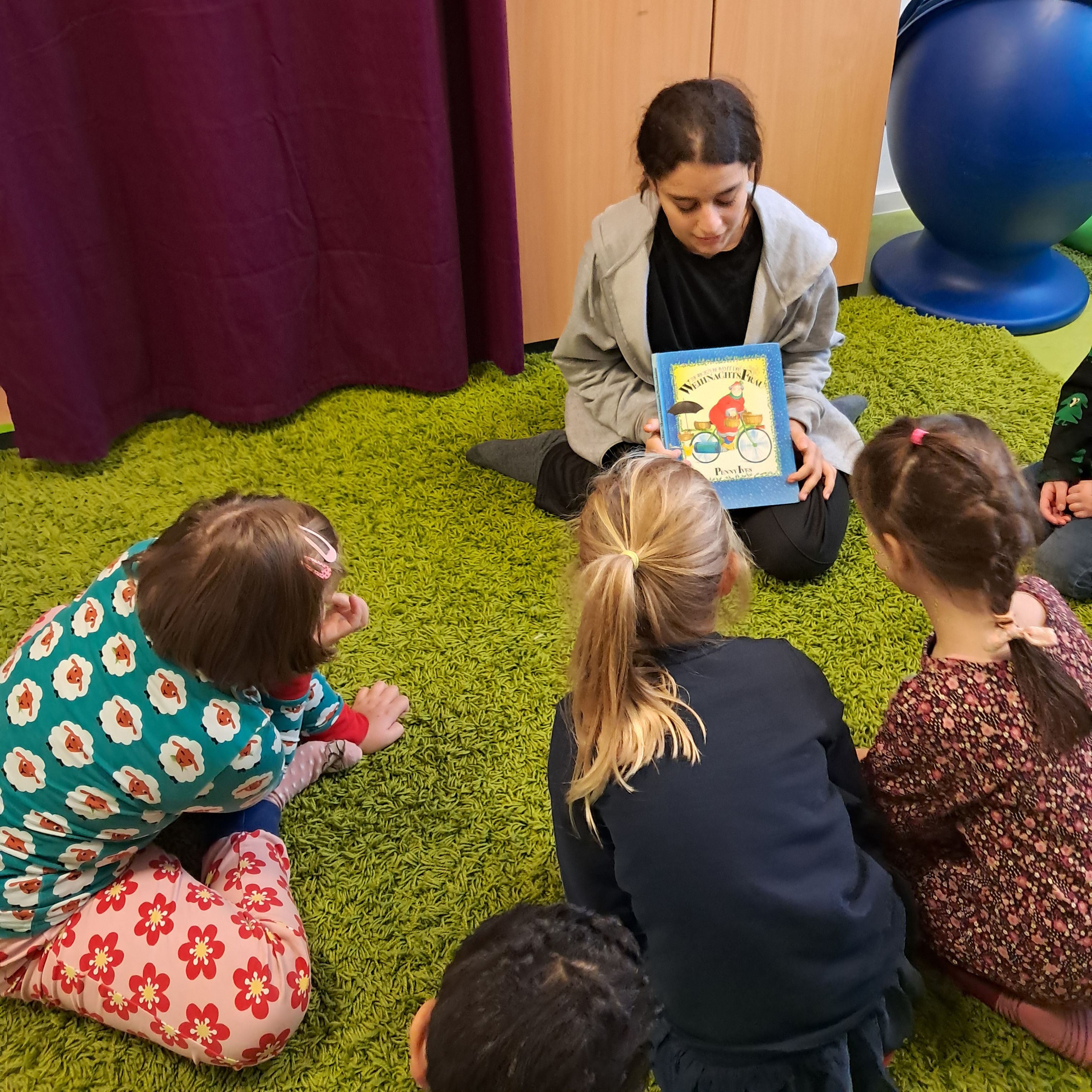 Die DiKiTa-Kinder genießen die Vorlesezeit mit den Schülerinnen. Foto: DiKiTa